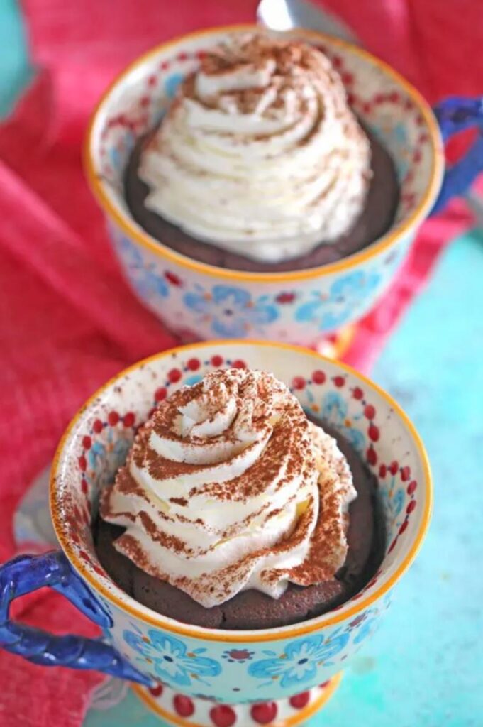 red velvet mug cakes topped with whipped cream