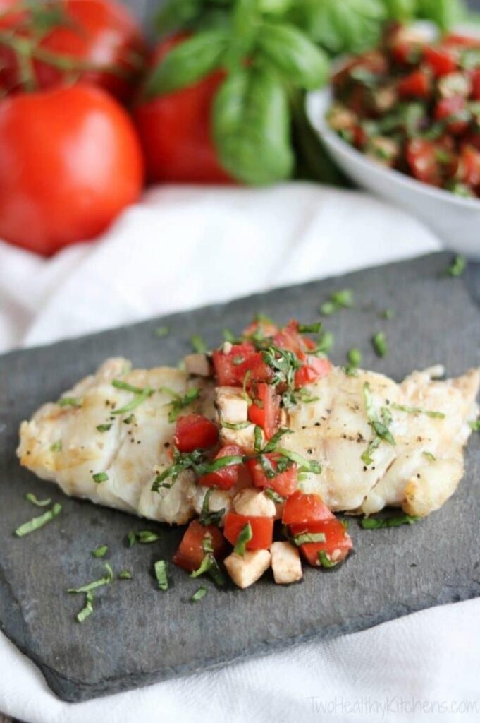 Caprese Grilled Chicken breast on a cutting board