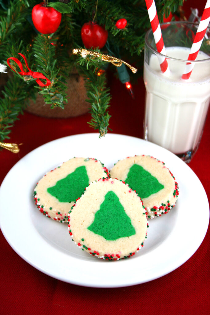 Slice and bake Christmas cookies on a plate with a glass of milk.