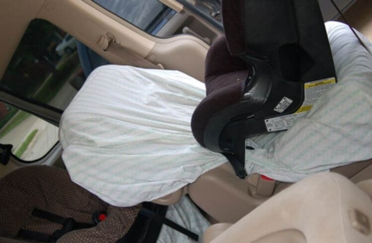 Car seat covered with crib sheet under a car seat to keep the seat clean