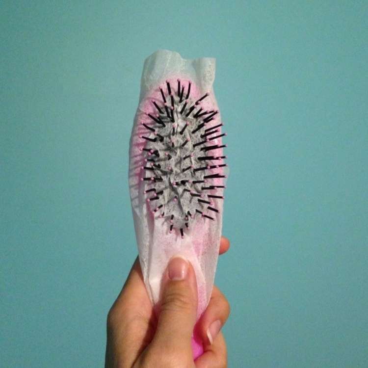 Hair brush covered with a dryer sheet