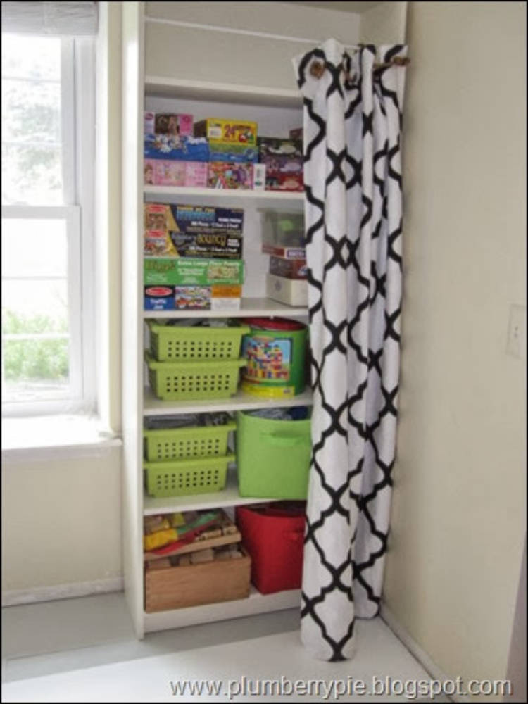 Picture of ots of toys and baskets on shelves - a decorative curtain is being used to hide them.