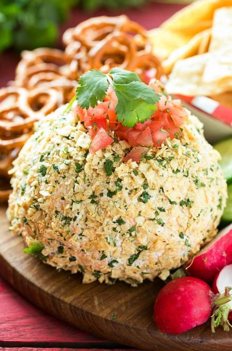 jalepeno cheddar cheese ball topped with diced tomatoes and a green leaf garnish