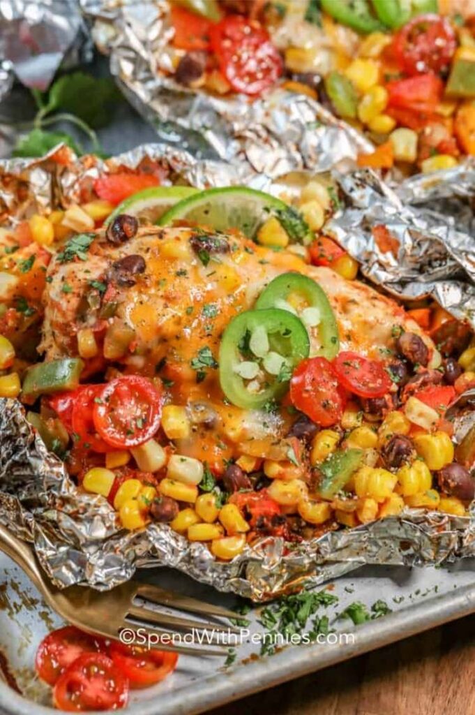 foil packet with chicken, corn, beans, and veggies cooked on it
