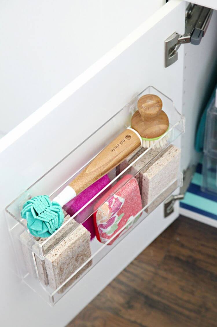 Acrylic spice rack attached to the back of a cabinet door to store sponges