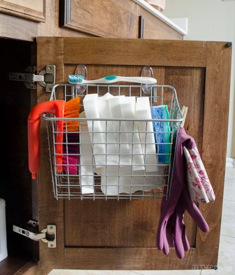 wire basket hanging on the back of a cabinet door for under bathroom sink storage