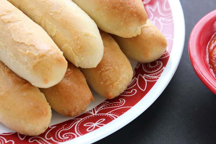 Breadsticks on a pile on a dish with red details