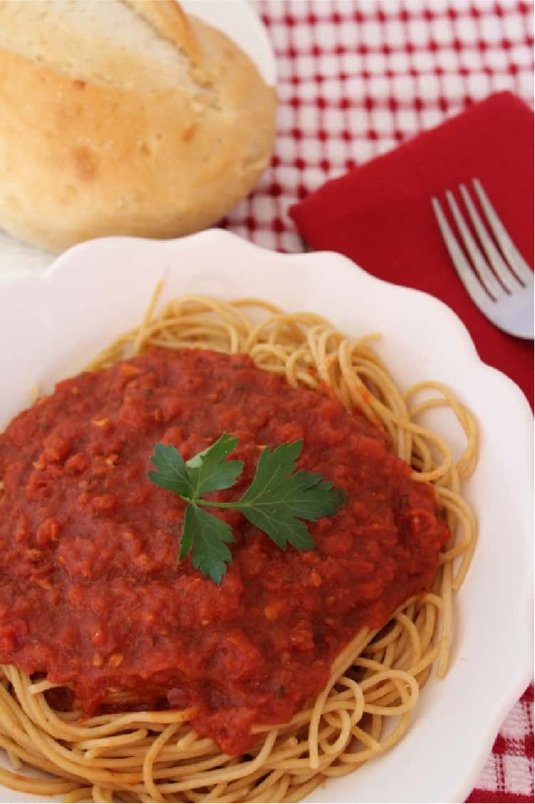 Marinara Sauce over a spaghetti pasta dish in a white plate
