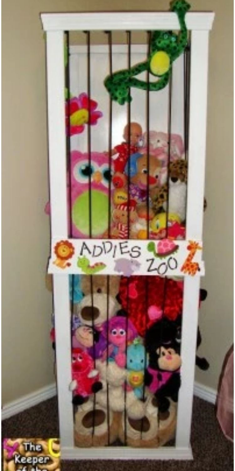 Stuffed animals stored in a wooden zoo cage