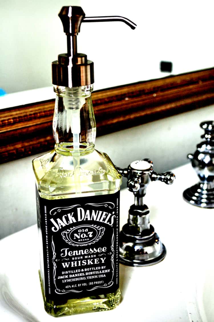 DIY soap dispenser made from a Jack Daniels bottle placed on the sink 