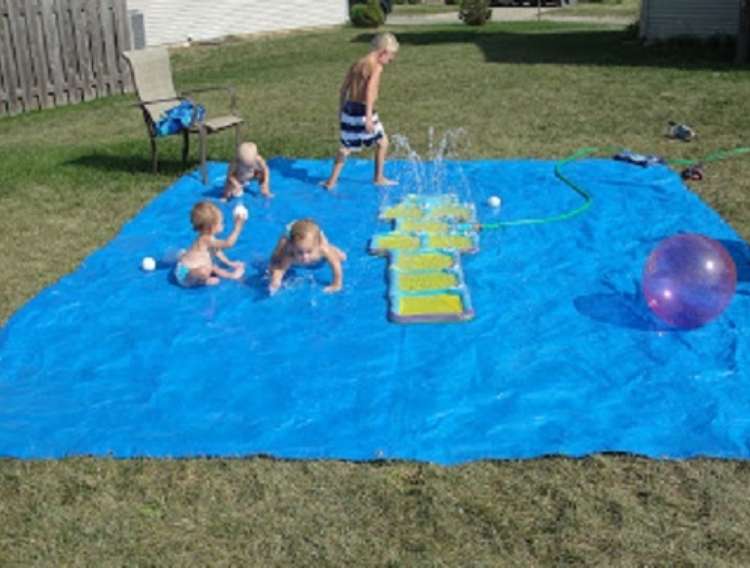 OneCrazyHouse Stay Cool without a pool 4 children playing on rubber mat on the ground with sprinkler spraying water in the middle