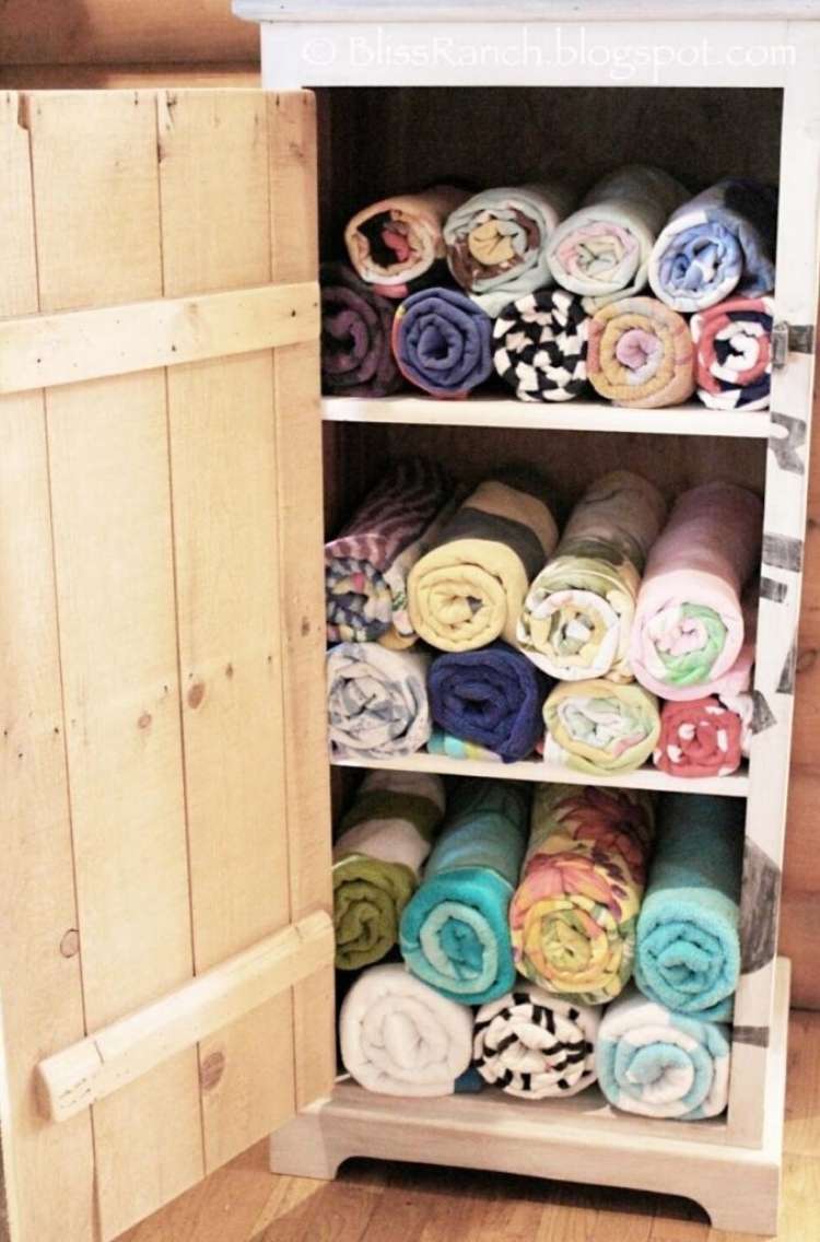 OneCrazyHouse pool storage DIY pool towel storage cabimet with towels rolled neatly on each shelf