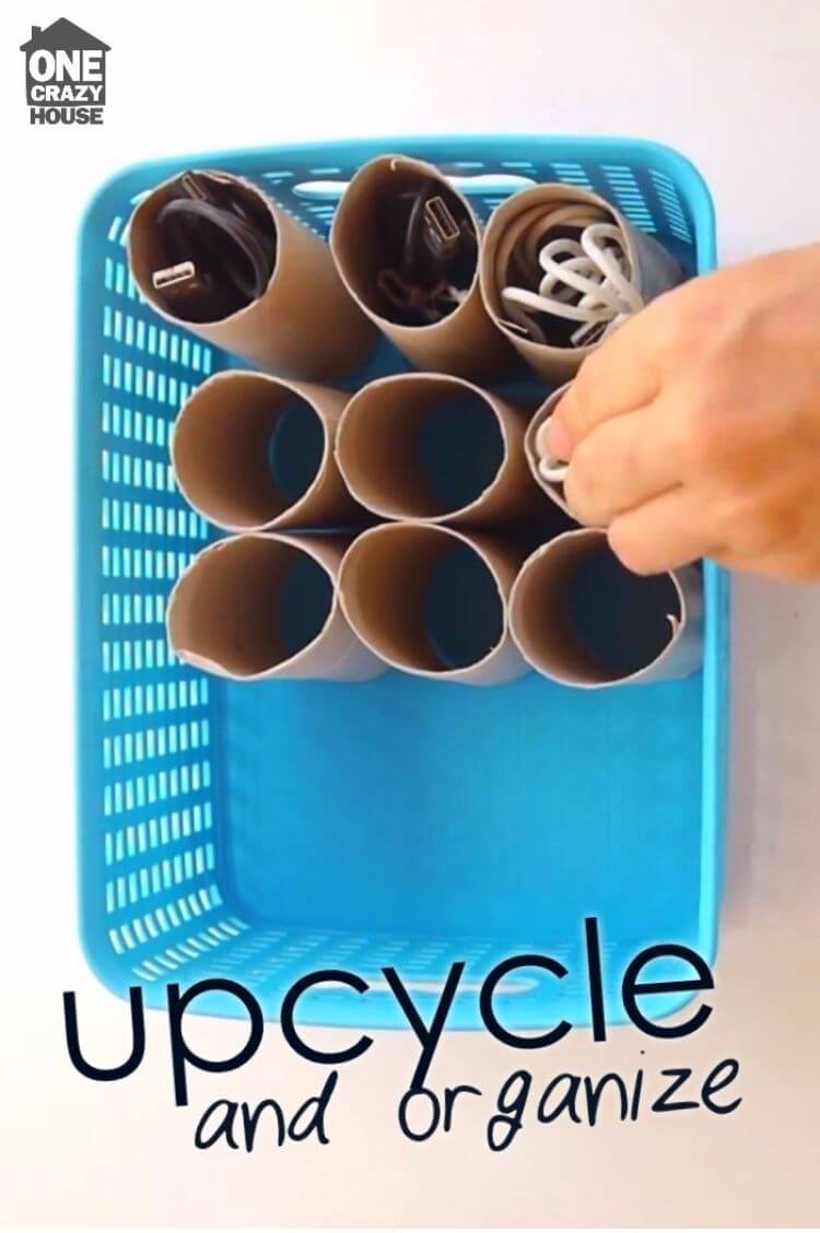 A basket containing empty toilet paper rolls filled with cords to organize different cables