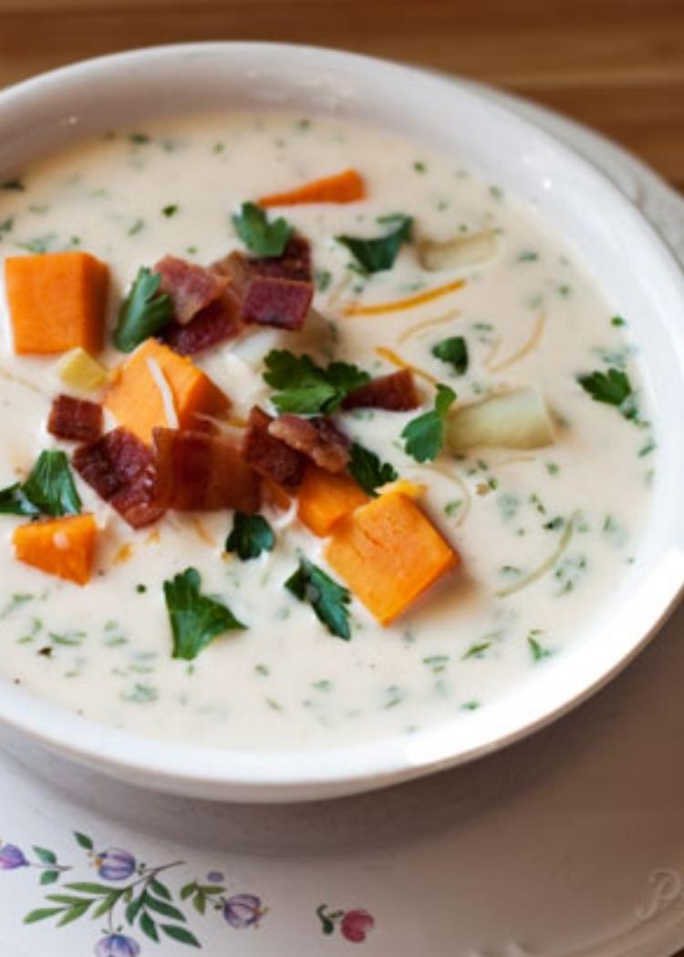 Instant Pot soup recipe for Chunky sweet potato cheese soup - A bowl of creamy, chunky sweet potato cheese soup loaded with tender chunks of sweet potatoes, russet potatoes, corn, and bacon in a white bowl.