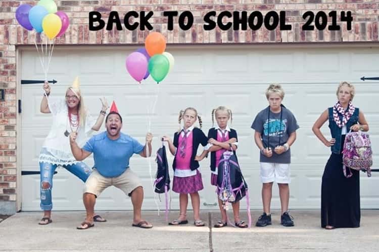 back to school photo ideas -  2 parents celebrate back to school while 4 kids stand there looking unhappy