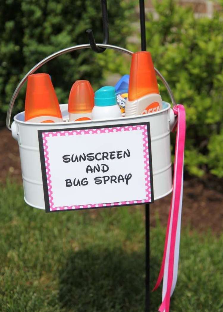Clever cookout- bucket of sunscreen and bug spray with a sign hanging from a garden stake