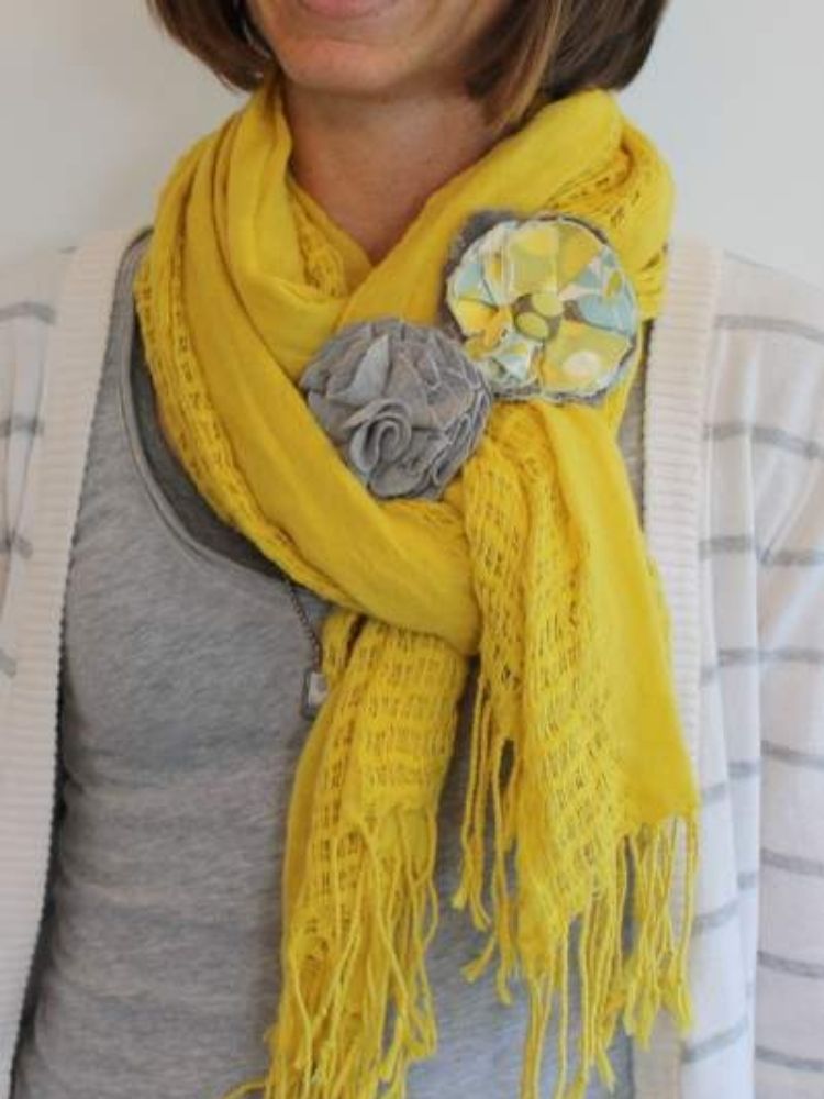fabric poppies pinned to a yellow scarf