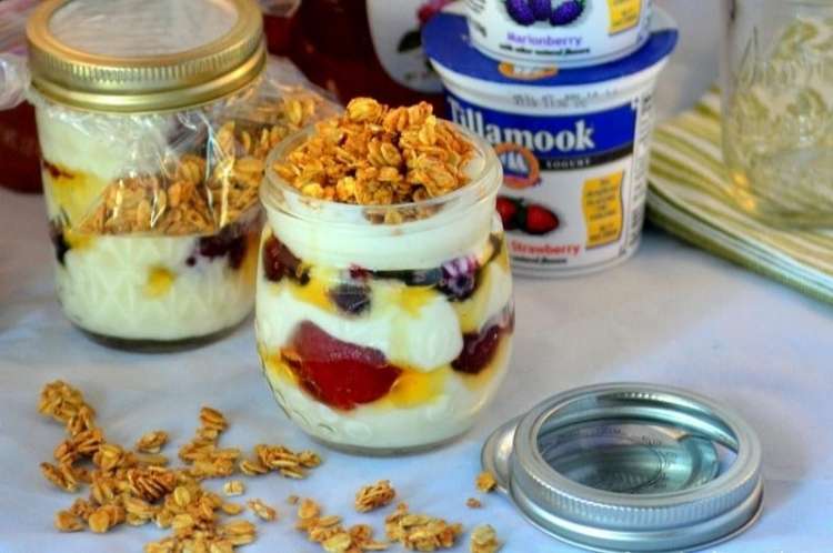 Counter with a clear glass jar full of vanilla parfait made from yogurt and fruit