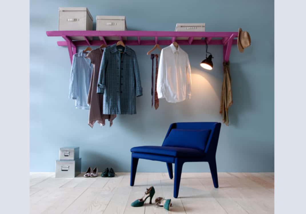 As a way to store clothes and accessories, affix a ladder horizontally on wall. This creates a shelf and hanging space.