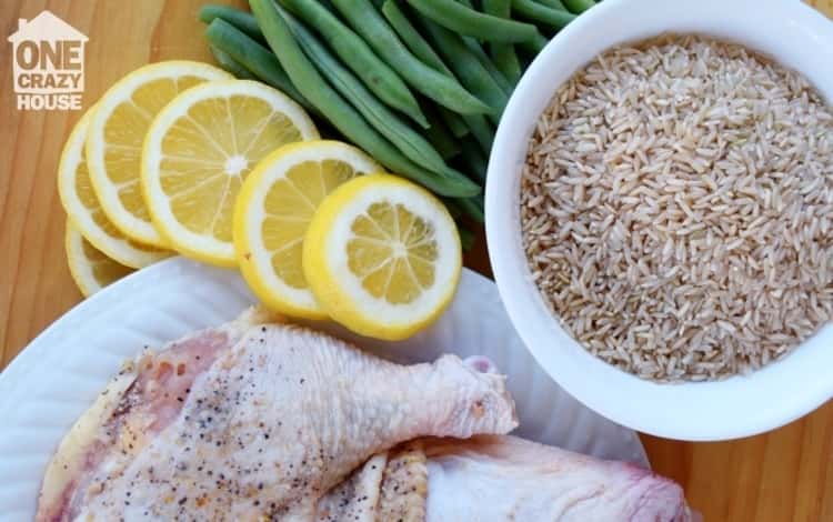 Ingredients for a slow cooker meal of lemon slices, rice, and chicken.