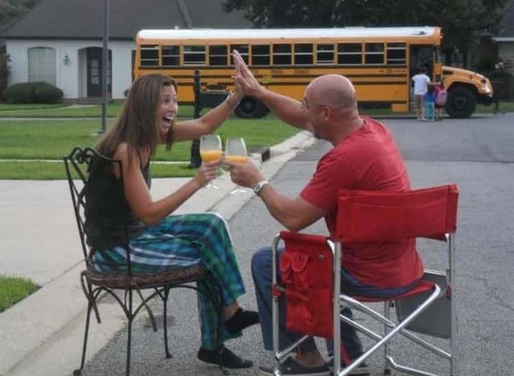 back to school photo ideas - parents celebrating with high fives and drinks as kids get on the school bus