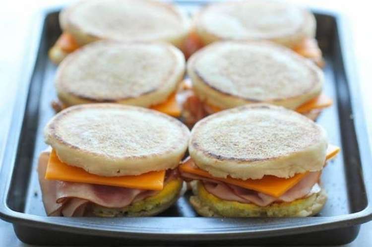 Tray with breakfast sandwiches made with English muffins, cheese, egg, and ham