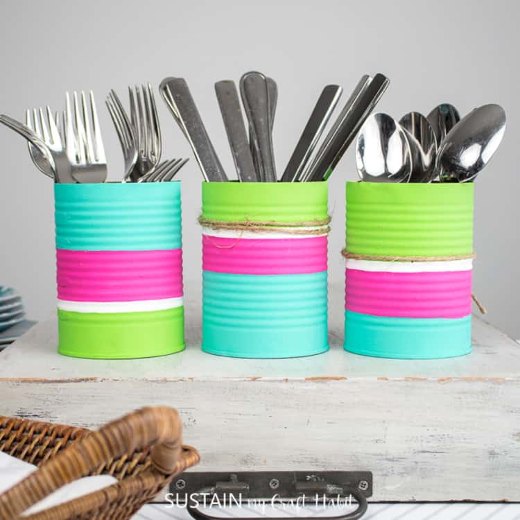 painted tin cans serving as utensil organizers