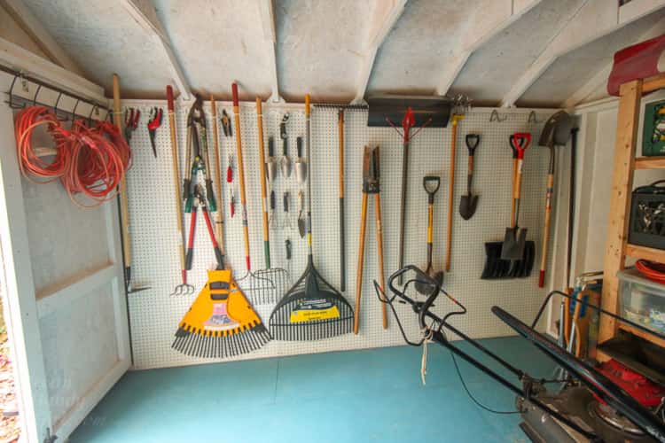garden tool organization with a pegboard. one wall in the garage as pegboard with garden tools hanging from it. 