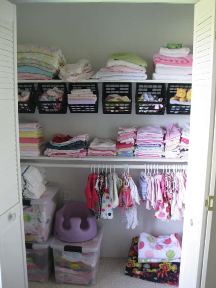 a children's closet with hanging baskets under the closet rod to organize their smaller clothing items