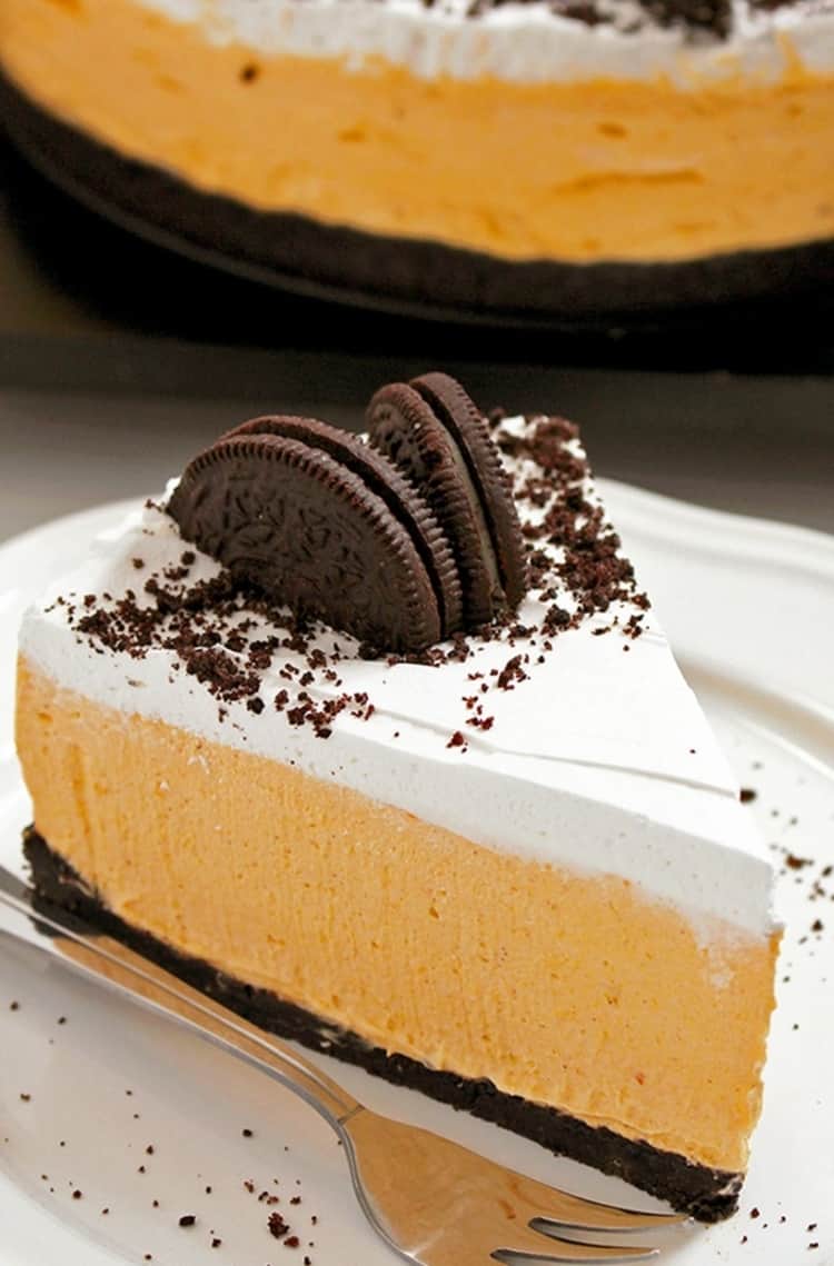 Features a slice of no bake pumpkin oreo cheesecake, topped with whipped cream and oreos.