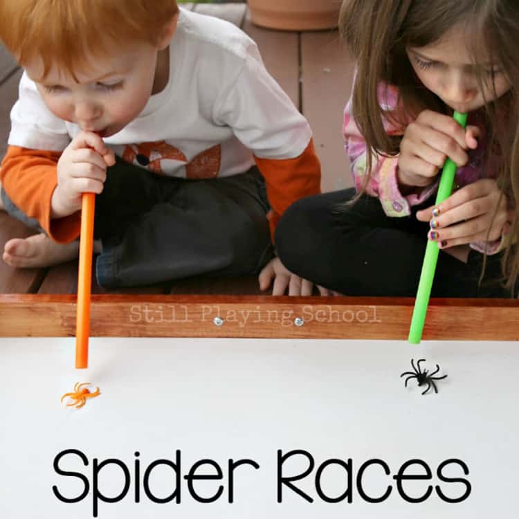 2 kids blowing their spiders in a competitive Halloween Spider Races game