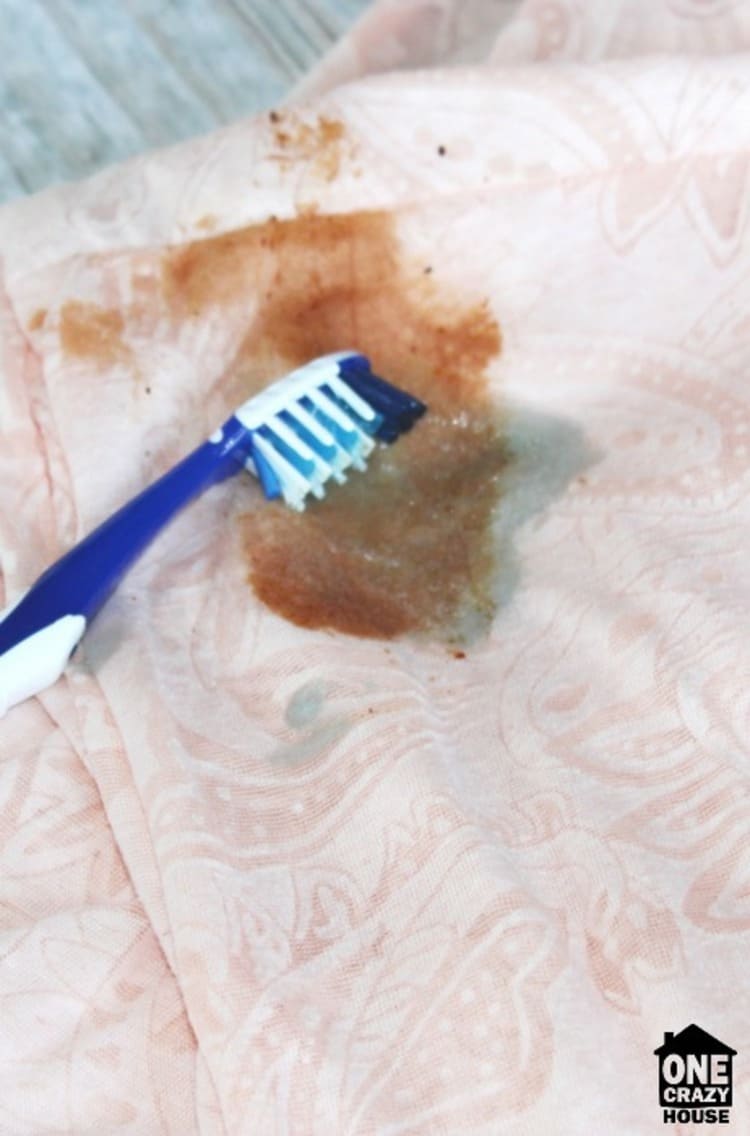 nasty stain treated with DIY stain cleaner and and old toothbrush on a pink blouse