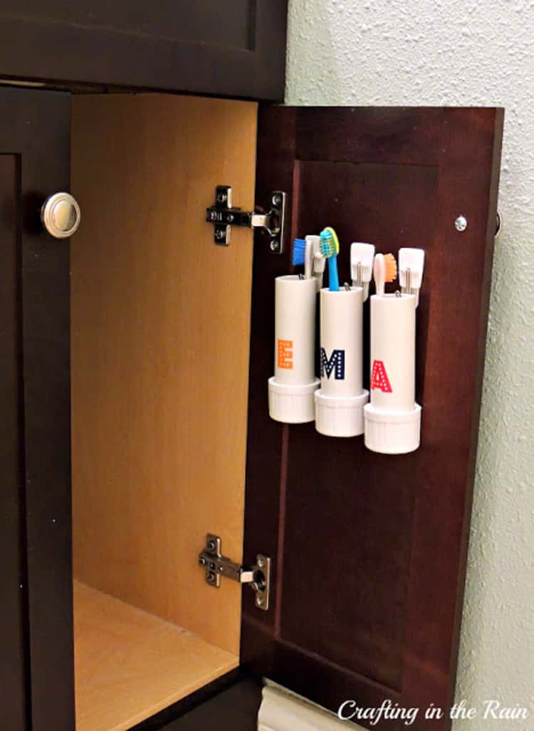 PVC Pipe Toothbrush holders on the inside of a cabinet door