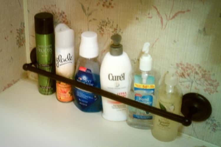 towel bar holding shampoo bottles in place